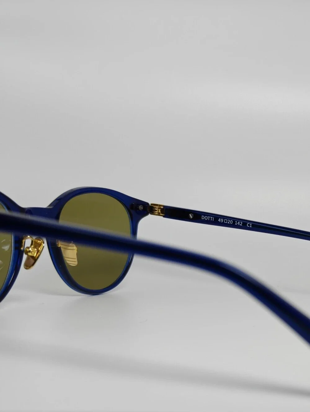 Dotti. Round Navy Translucent frame. Gold Hinge Extends to frame front.